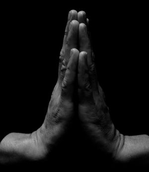 Close-up on hands in a meditative gesture, calm background.